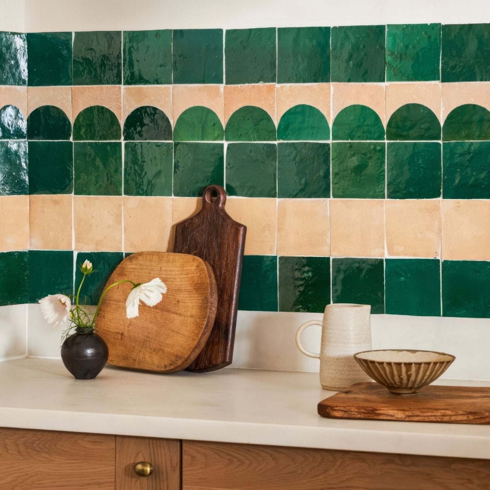 Dark ceramic vase holding white flowers displayed on medina moss green belen handmade moroccan zellige tile