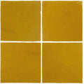 Four square mustard-yellow handmade ceramic moroccan zellige tiles arranged in a grid pattern