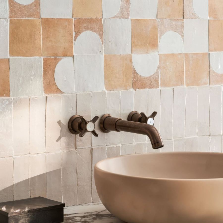 Brass wall-mounted faucet with cross-shaped handles and curved spout paired with Medina pure white Belen handmade Moroccan zellige tile