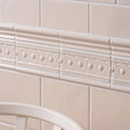 Cream-colored ceramic tile border melford baroque with raised oval and dot patterns for decorative edging