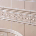 Beige ceramic melford half tile border with raised circular and dot patterns for decorative edging