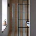Menara white arches porcelain shower stall with modern beige and gray striped tiles framed by black metal grid lines