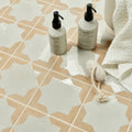 Two white wildsmith skin pump bottles with black caps on menara white star porcelain patterned tile floor