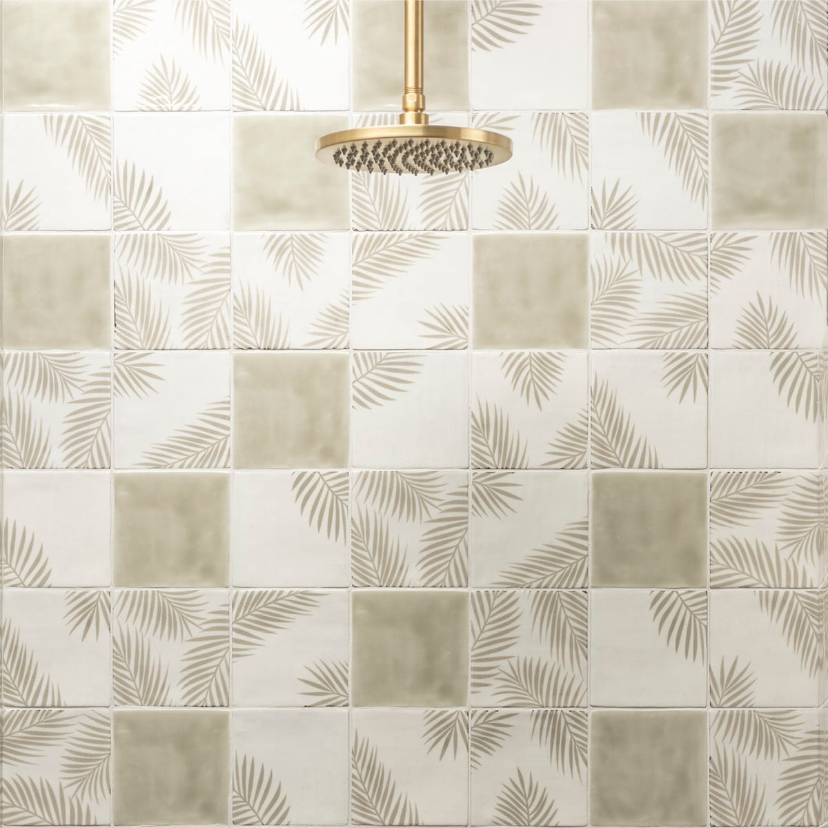 Gold-toned circular showerhead with multiple spray nozzles for Mere Field Tile bathroom installation