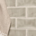 Beige rectangular mere half tile wall tiles with subtle marble-like veining pattern in ceramic material