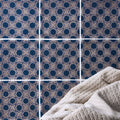 Beige textured towel from merles on truffle resting against navy blue and beige geometric patterned tiles