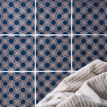 Beige textured towel from merles on truffle resting against navy blue and beige geometric patterned tiles