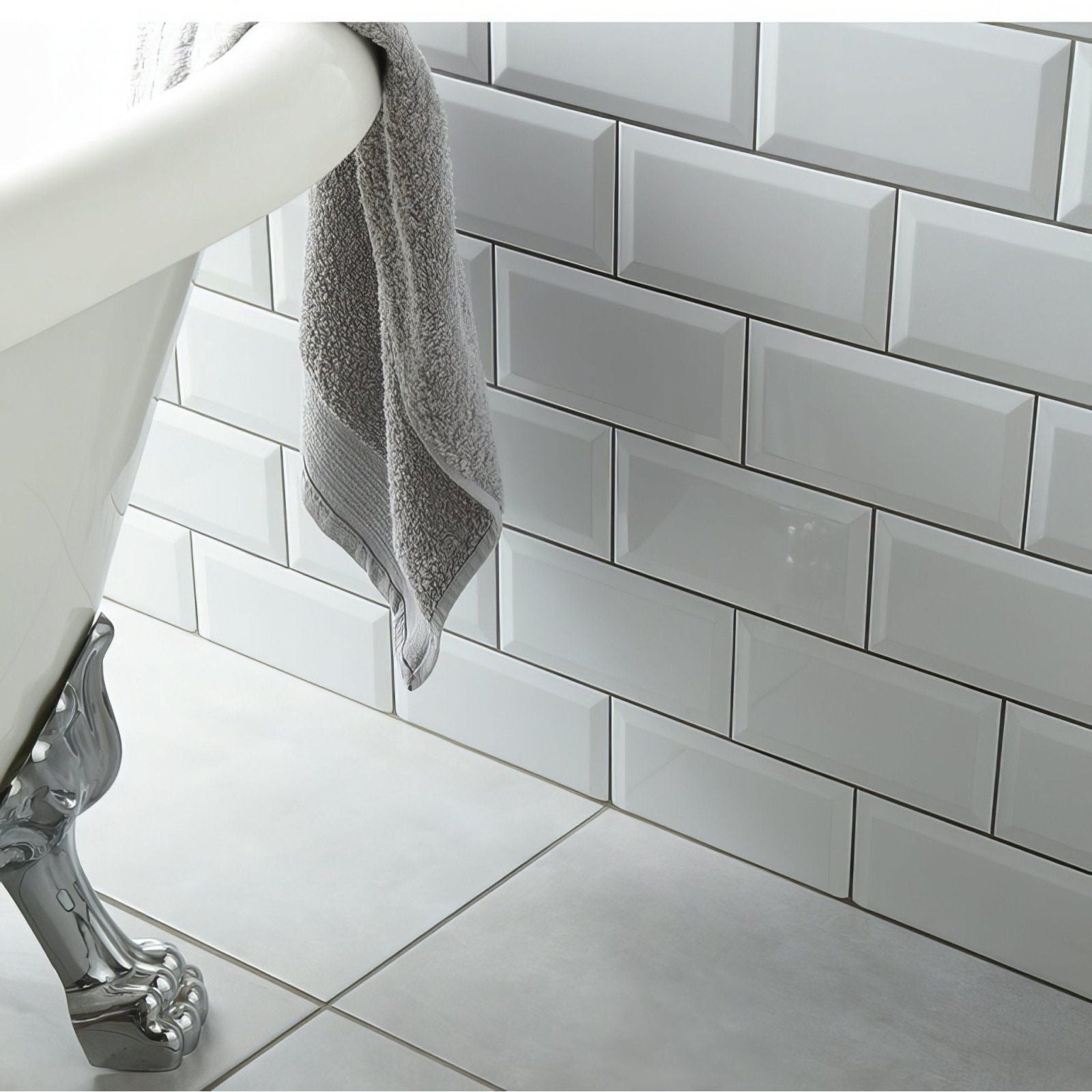 A gray textured towel hanging over the curved edge of a white ceramic gloss clawfoot bathtub metro white ceramic gloss