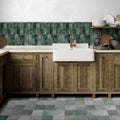 White farmhouse sink with brass faucet set into rustic wooden cabinets in the metropolitan barcelona collection