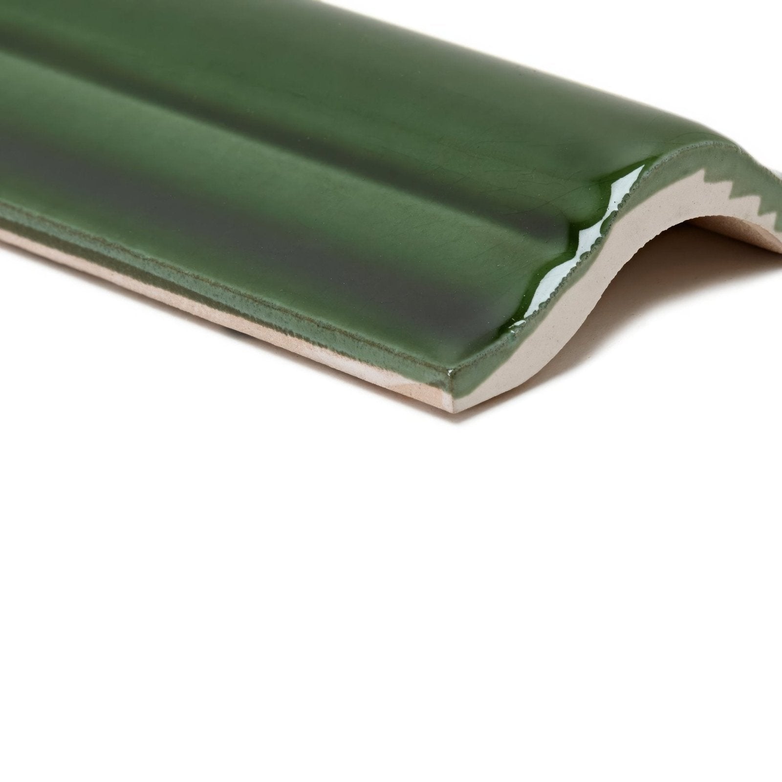 A glossy forest green ceramic metropolitan brompton road trim tile with a curved ridged edge and white underglaze finish