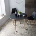 Black round dining table with light wood legs from Mezzo mixed melange collection for stylish dining spaces