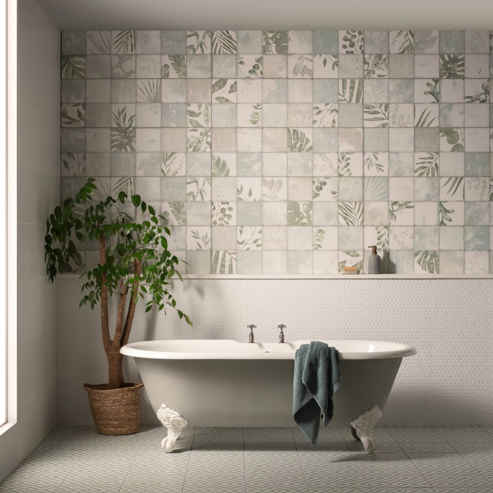 White clawfoot bathtub with ornate feet and a dark green towel draped over the side in mini white penny round style