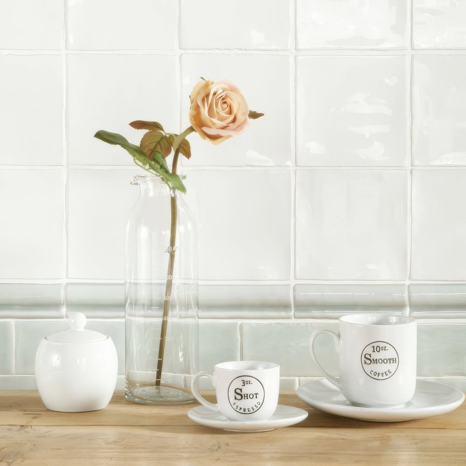 A delicate peach-colored rose in a tall clear glass vase showcased against mint half tile wall tiles
