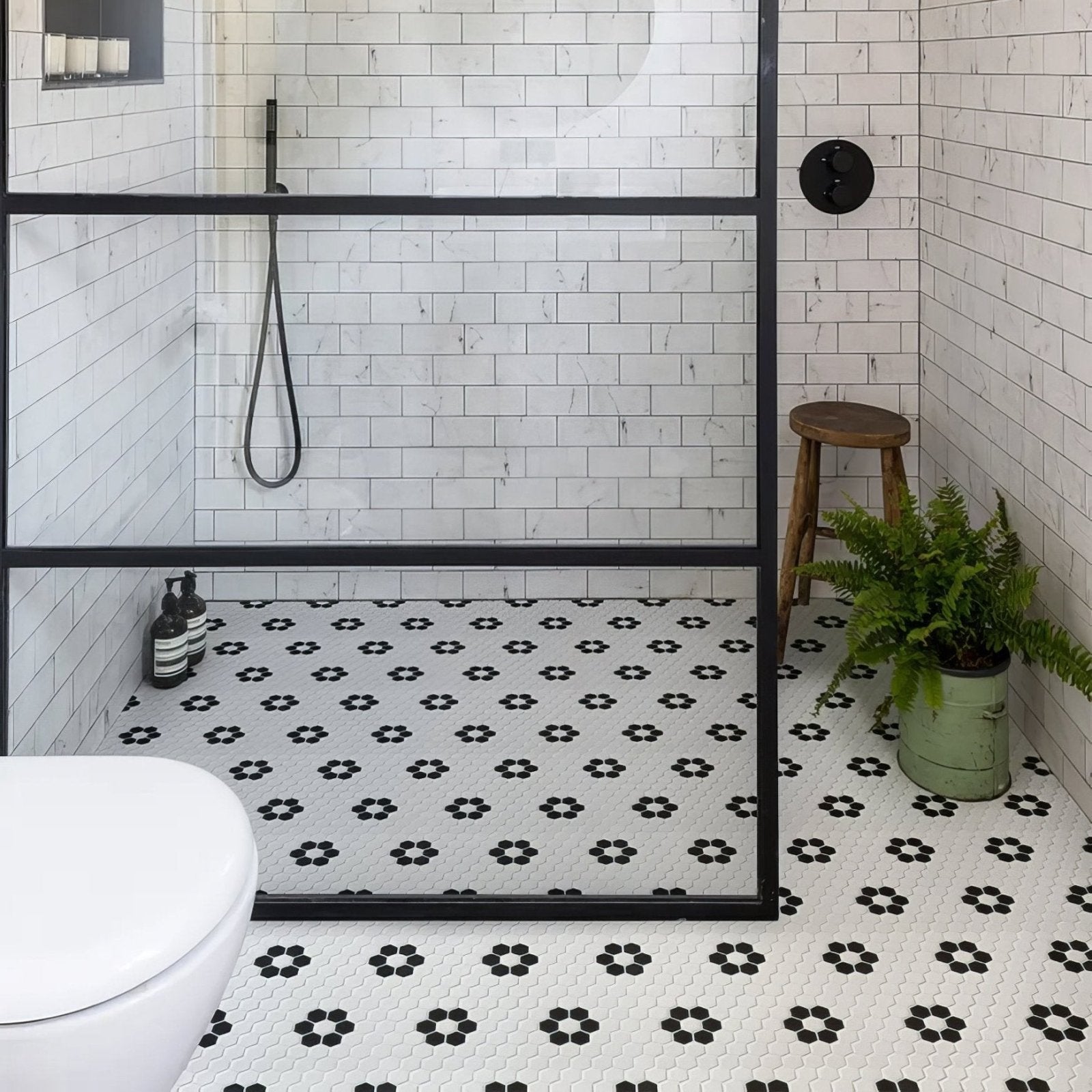Mono Hex Porcelain Mosaic Daisy white hexagonal porcelain mosaic with a black metal shower door frame