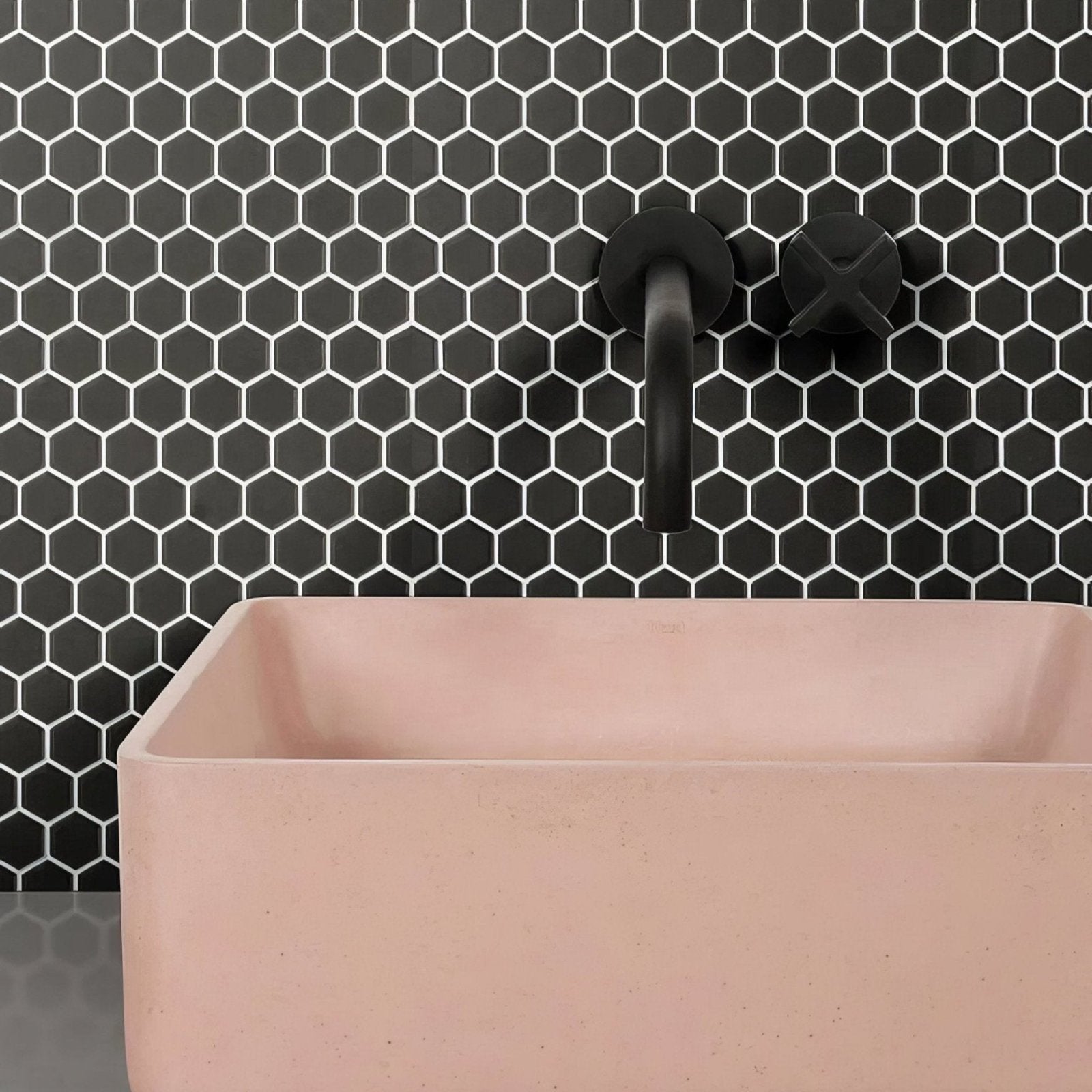 A matte black wall-mounted mono hex porcelain mosaic noir faucet with a sleek modern design and x-shaped handle