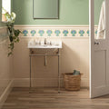 White ceramic pedestal sink with polished brass legs and fixtures featuring Montmartre tube-lined tile in county white