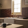 White farmhouse sink with polished chrome faucet and vintage style handles featured with moor brick tile backdrop