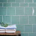Half tile moselle linen towels stacked in soft blue and beige with a sprig of greenery for home decor