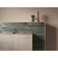 Dark green textured ceramic tiles with vertical ridges arranged in a modern geometric pattern from mussa way green brillo