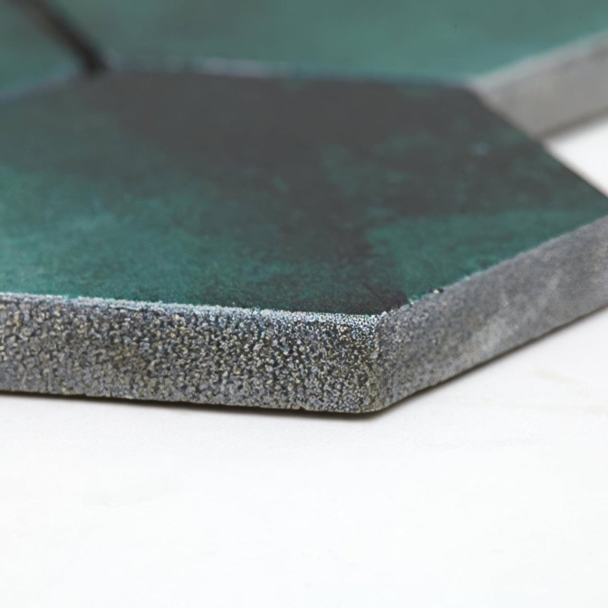 Hexagonal tile nebula green with a matte teal surface and textured speckled gray edges for stylish flooring and walls