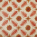 Patterned tile with repeating red and orange floral and star motifs on textured off-white background from neisha crosland atlas pine flower paprika