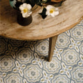 Patterned Nina Campbell Cochin Blue porcelain floor tiles with intricate floral and geometric designs in muted gray olive green and cream tones