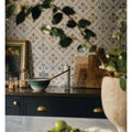 Green and white ceramic bowl with wooden spoon inside on a nina campbell goa indigo chocolate porcelain tile