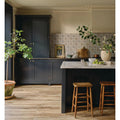 Dark navy blue kitchen cabinets with gold hardware and marble countertop featuring nina campbell goa indigo chocolate porcelain tile