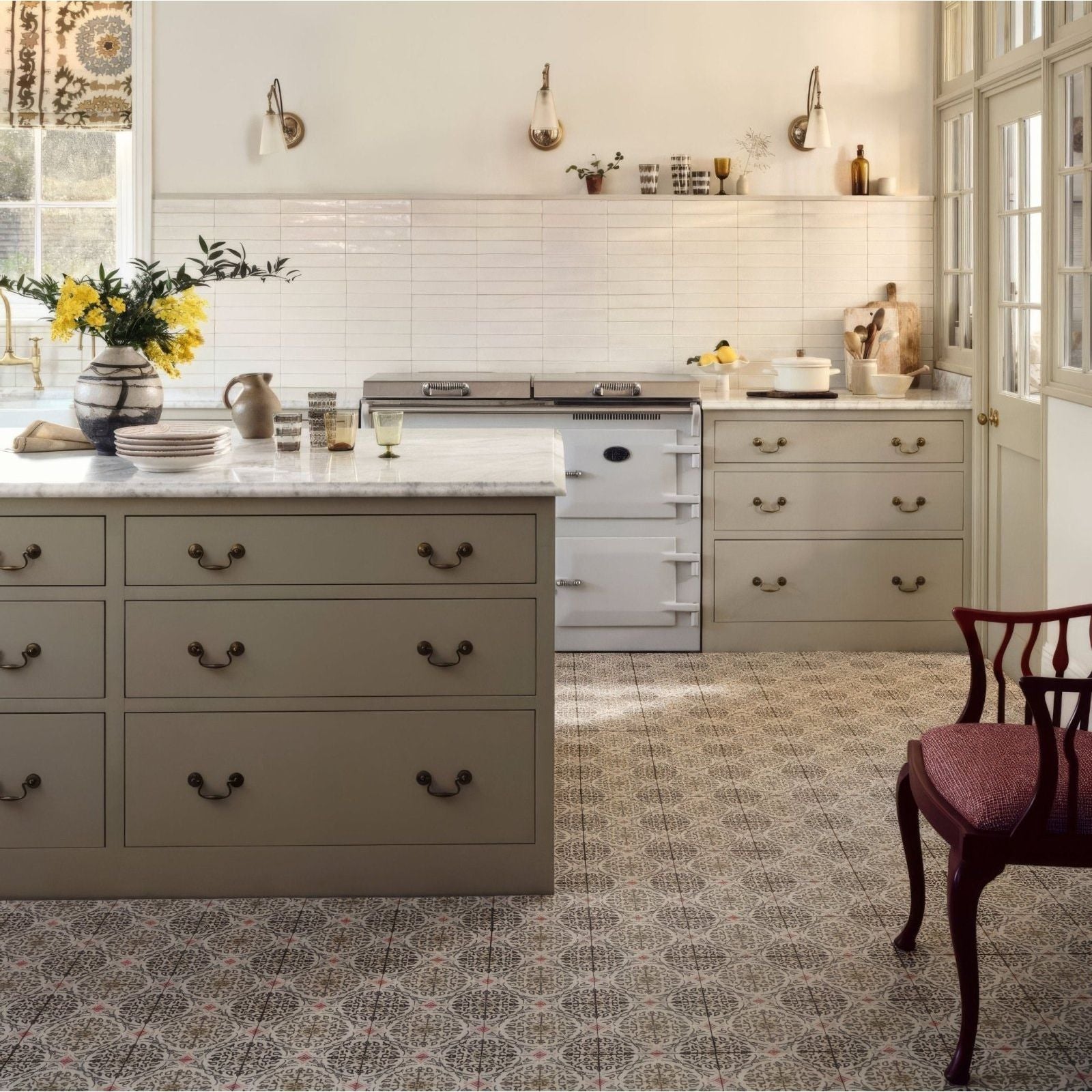 White vintage-style aga range cooker with brass handles and knobs featured in nina campbell la moulade chocolate porcelain tile setting