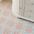 Patterned vinyl floor tiles with a geometric design in pink blue and beige from nina campbell seville coral aqua porcelain tile