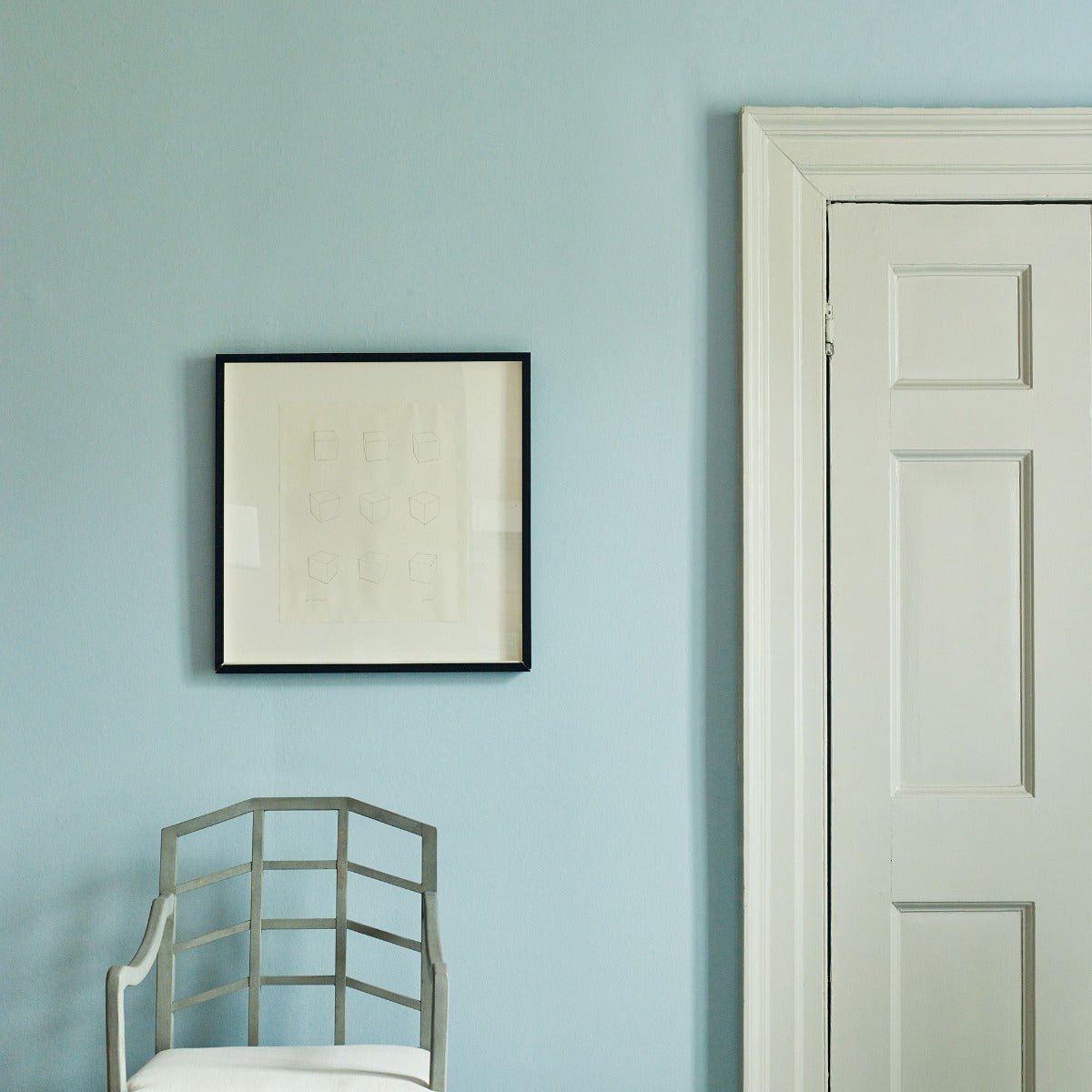 Nordic Light minimalist black-framed artwork with cream mat and embossed lettering on light blue wall