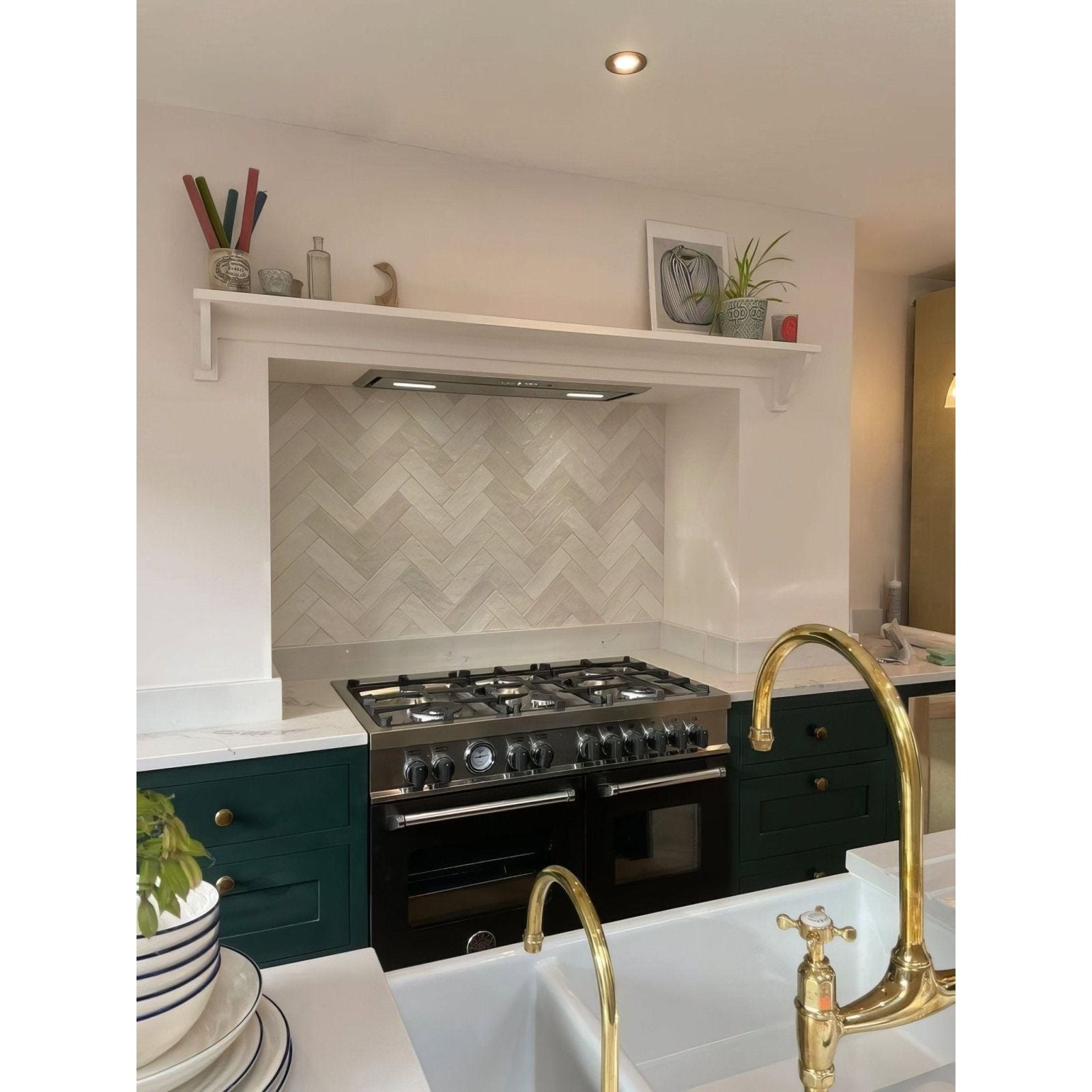 Black stainless steel gas range with gold-finished faucets and handles in oasis ceramic white gloss finish