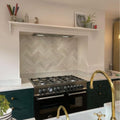 Black stainless steel gas range with gold-finished faucets and handles in oasis ceramic white gloss finish