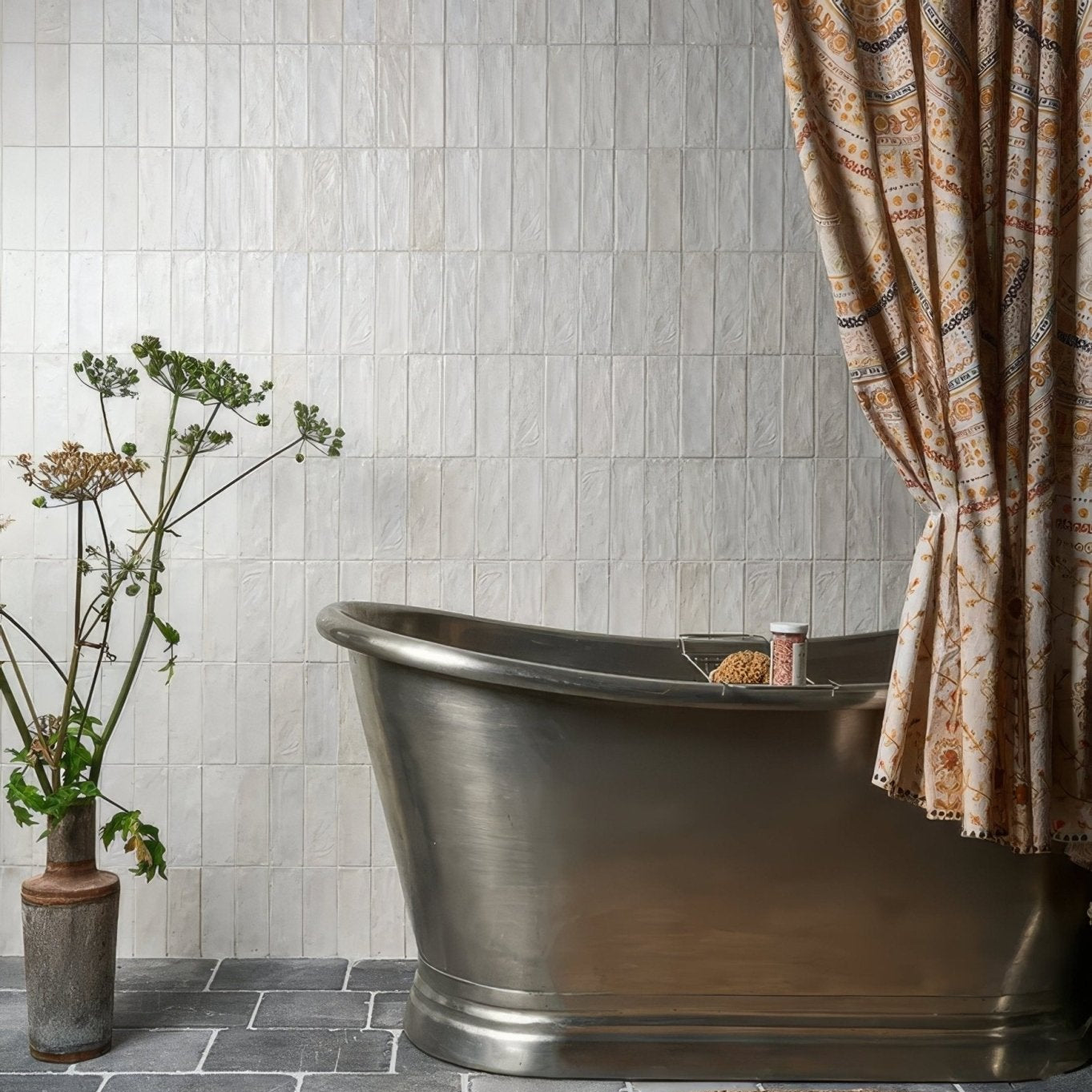 A sleek metallic freestanding bathtub oasis veloute ceramic white matt with brushed finish and elegant curves