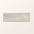 A rectangular light gray ceramic tile with a subtle textured surface from oasis veloute white matt collection