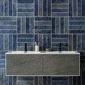 Modern gray stone-look vanity with white countertop and two black faucets in oken brick blue product line