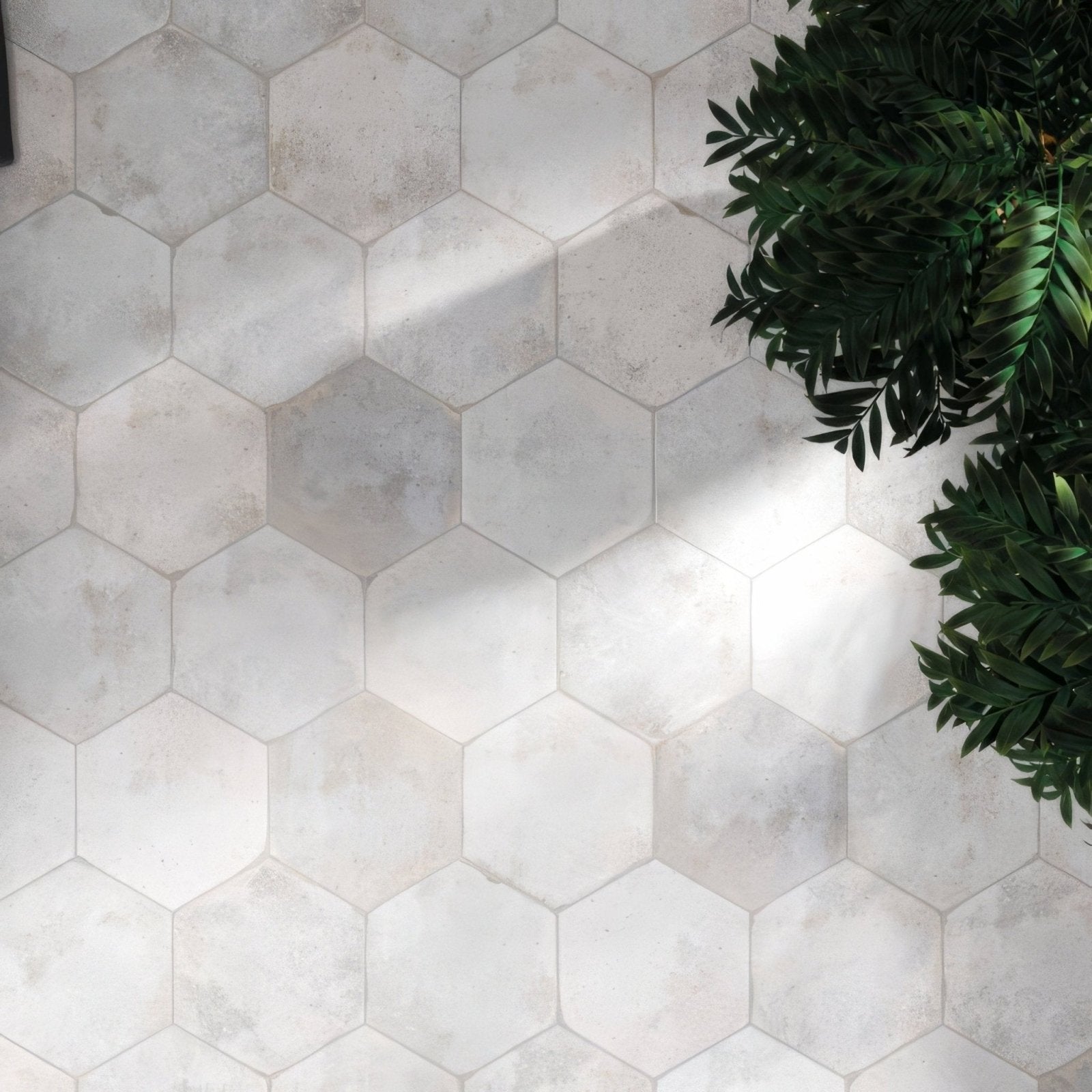 Oken hexagon white ceramic floor tiles with a subtle gray marbled texture in a hexagonal shape