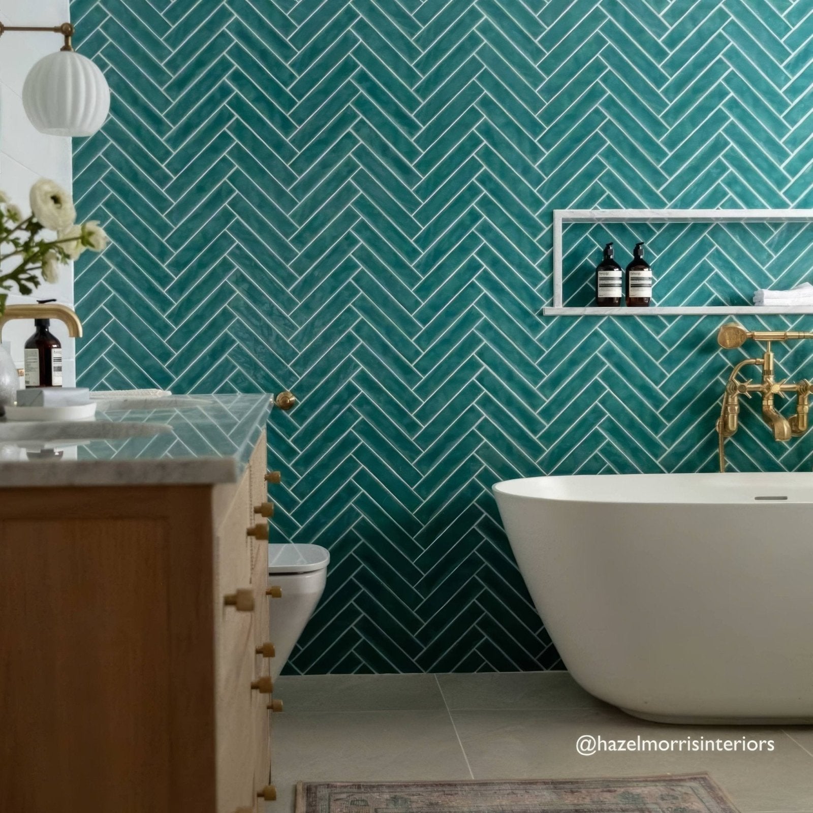 Teal herringbone patterned onda aquamarine wall tiles with white grout ideal for bathroom walls