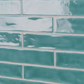 Onda aquamarine wall tiles featuring teal green rectangular subway tiles with a glossy finish and white glaze accents