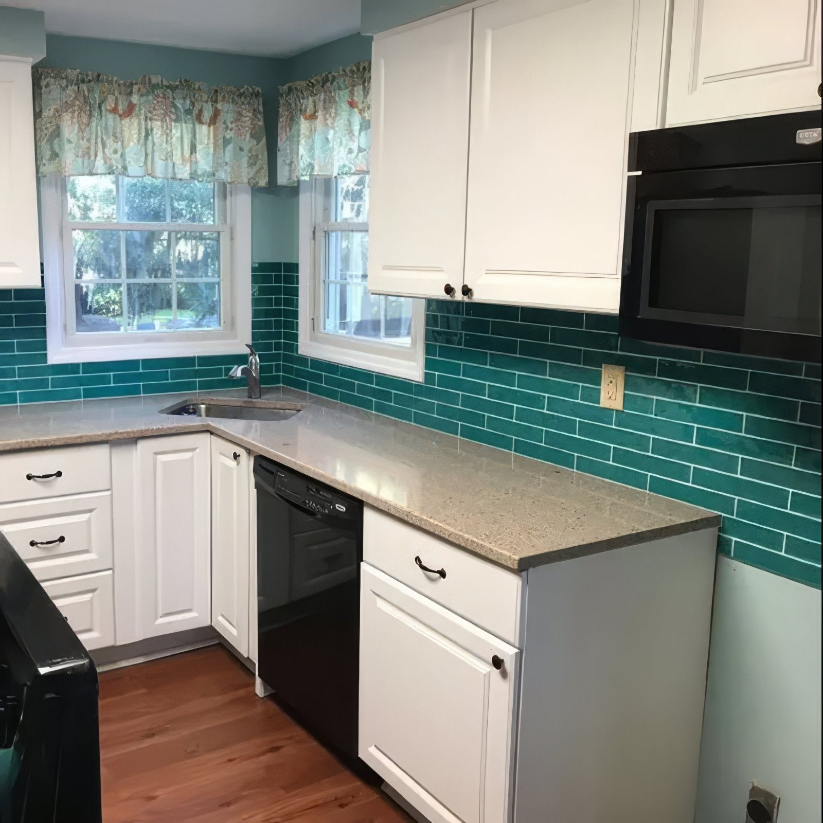 White kitchen cabinets with black hardware featuring onda aquamarine teal subway tile backsplash wall tiles