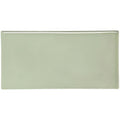 A sleek rectangular ceramic orford half tile with smooth matte sage green finish and rounded edges