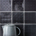 Ormeaux on Sloe gray ceramic teapot with vertical ridges and matching lid against dark patterned tiles