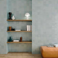 Shelving unit with books and decorative items against a tiled wall.