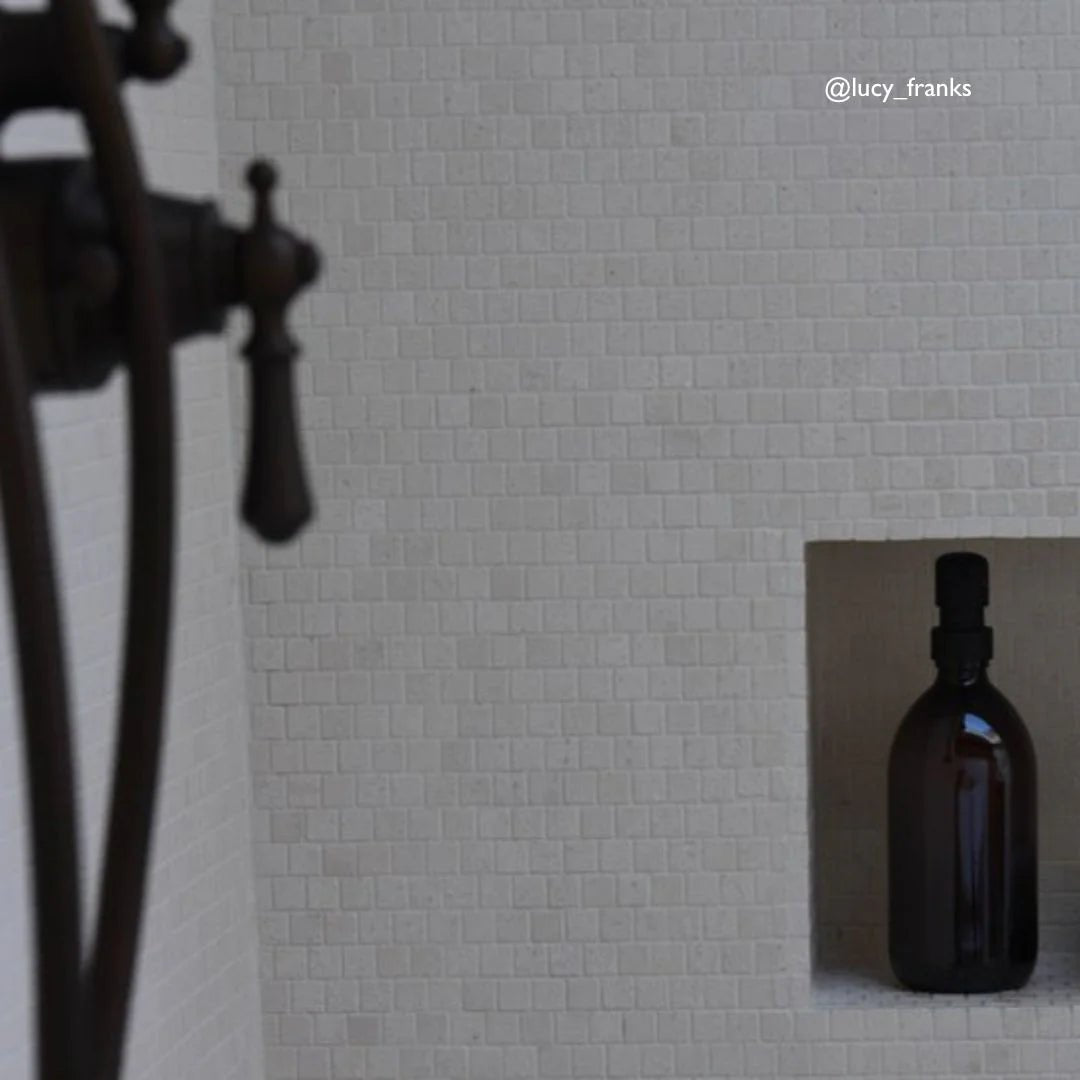 Palio Limestone Brick Mosaic Tile white limestone brick mosaic with an amber bottle in a niche