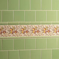 Palm green field tile decorative ceramic strip with pomegranates and foliage in earthy tones on cream background