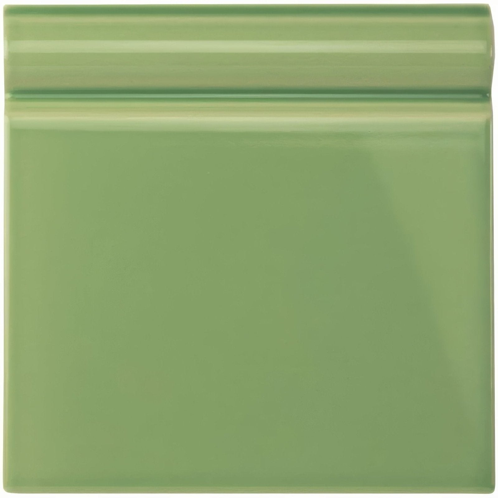 A glossy sage green ceramic palm green skirting tile with a raised beveled edge for wall edging