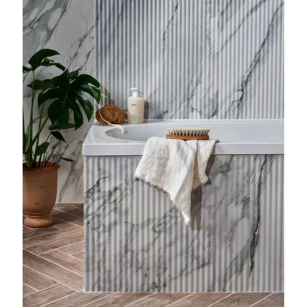 Palm Springs Porcelain Cerulean Fluted white and grey fluted marble-effect tiles with a bathtub and towel