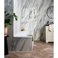 Palm Springs Porcelain Cerulean Plain white marble-effect tiles with a freestanding bathtub and green towel