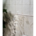 White marble-effect porcelain wall panel with vertical ridges and dark veining from palm springs moulding