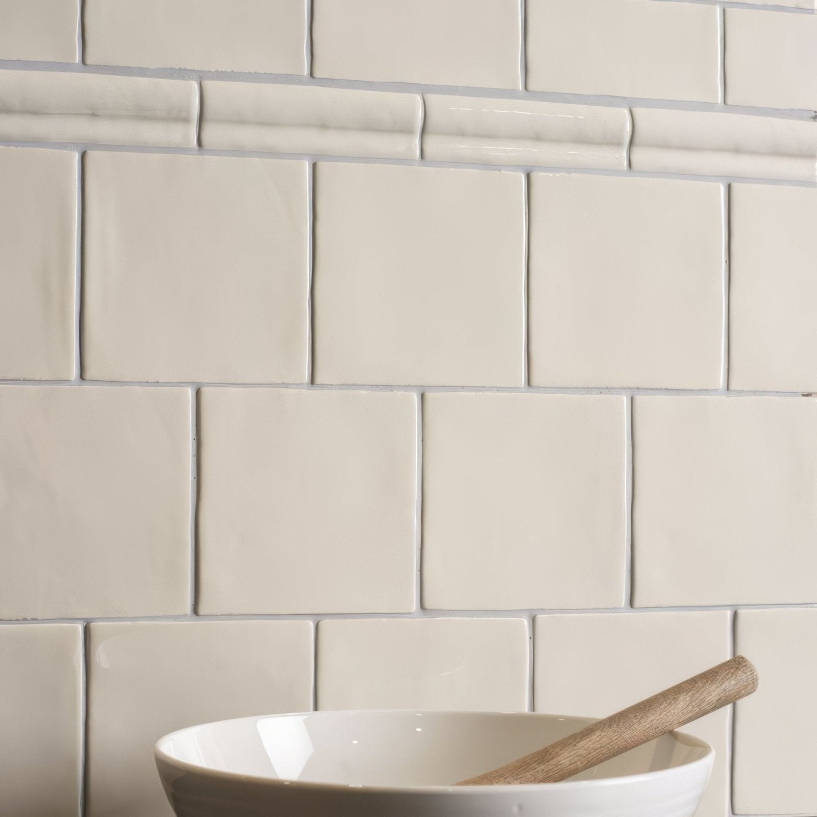 Cream-colored ceramic palomino half tile wall tiles with subtle glossy finish arranged in classic subway grid pattern